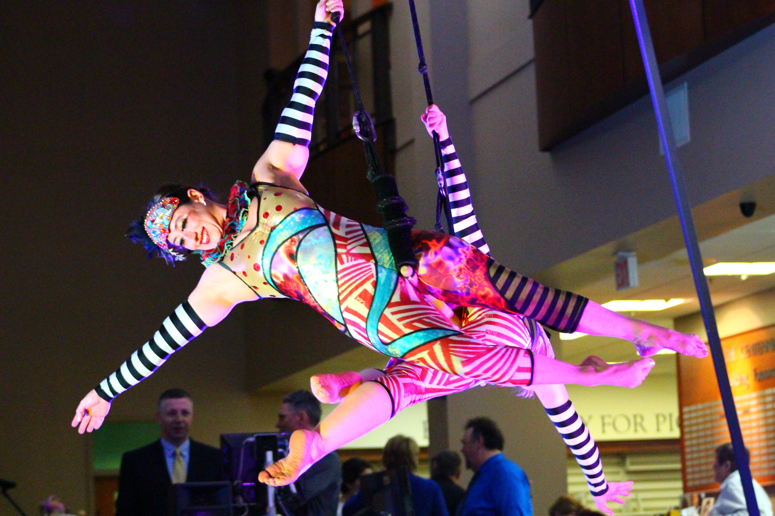 Aerial performers in costume suspended from ropes