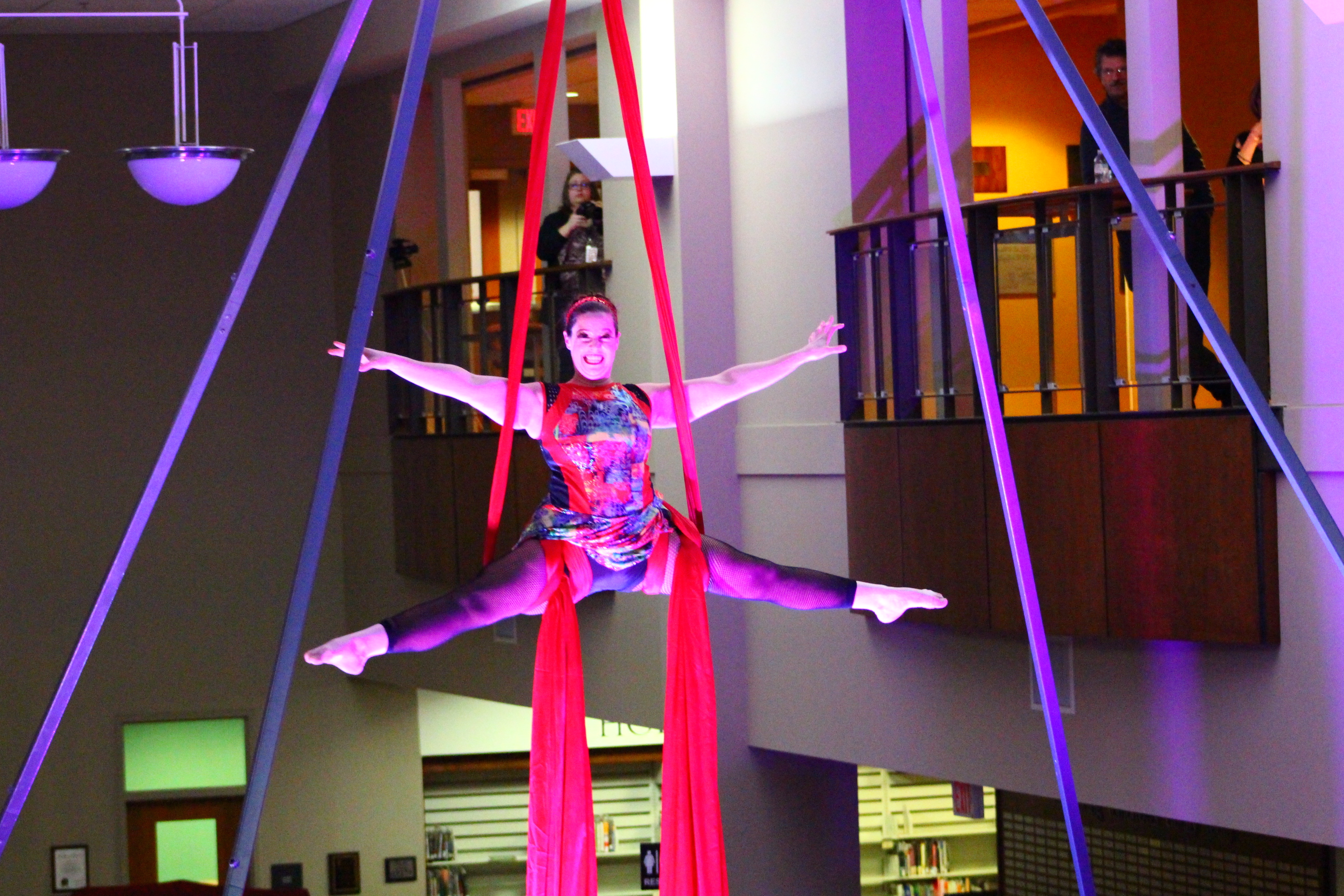 Aerial performer suspended from ropes wrapped around her limbs