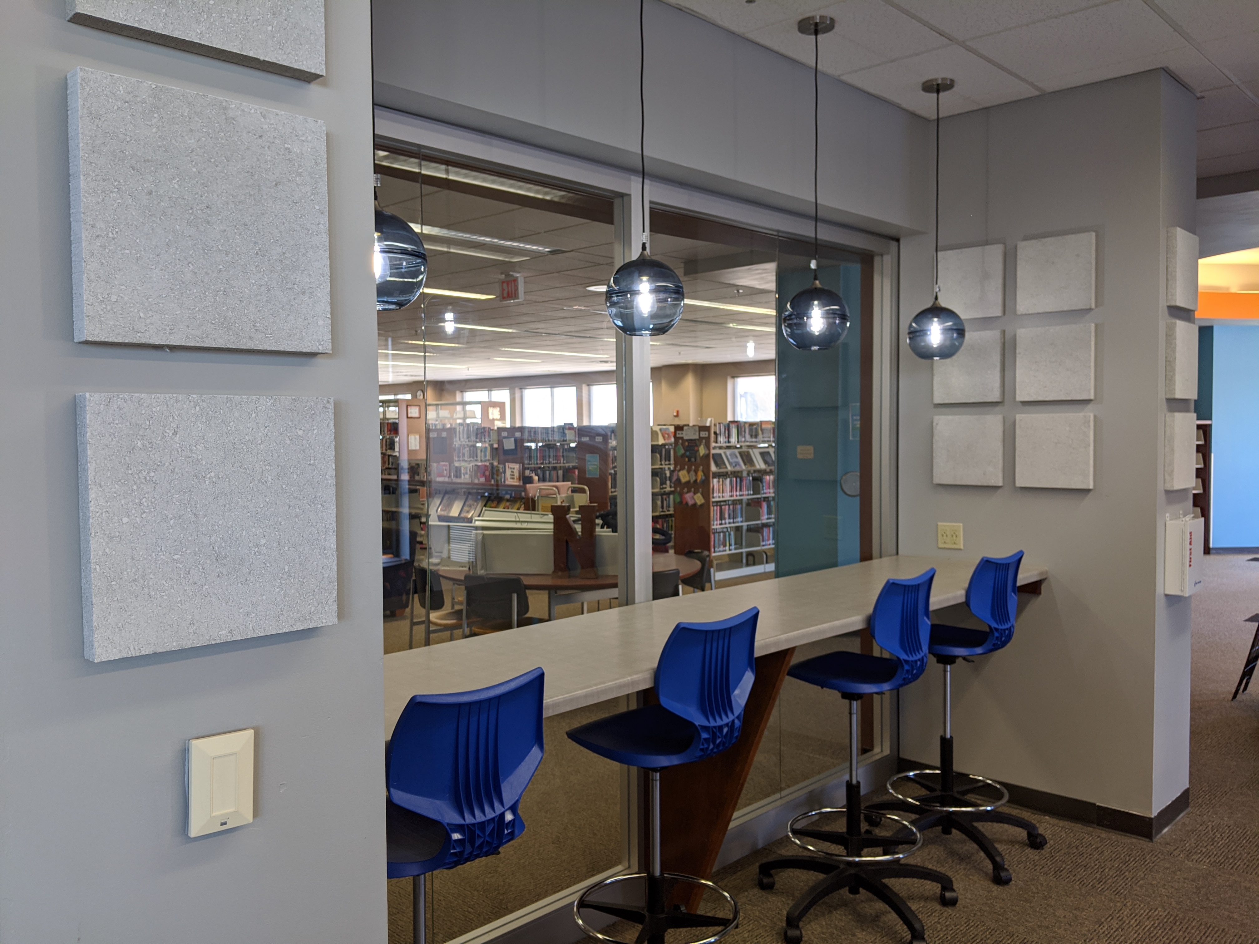 Idea box seats along counter under blue light fixtures