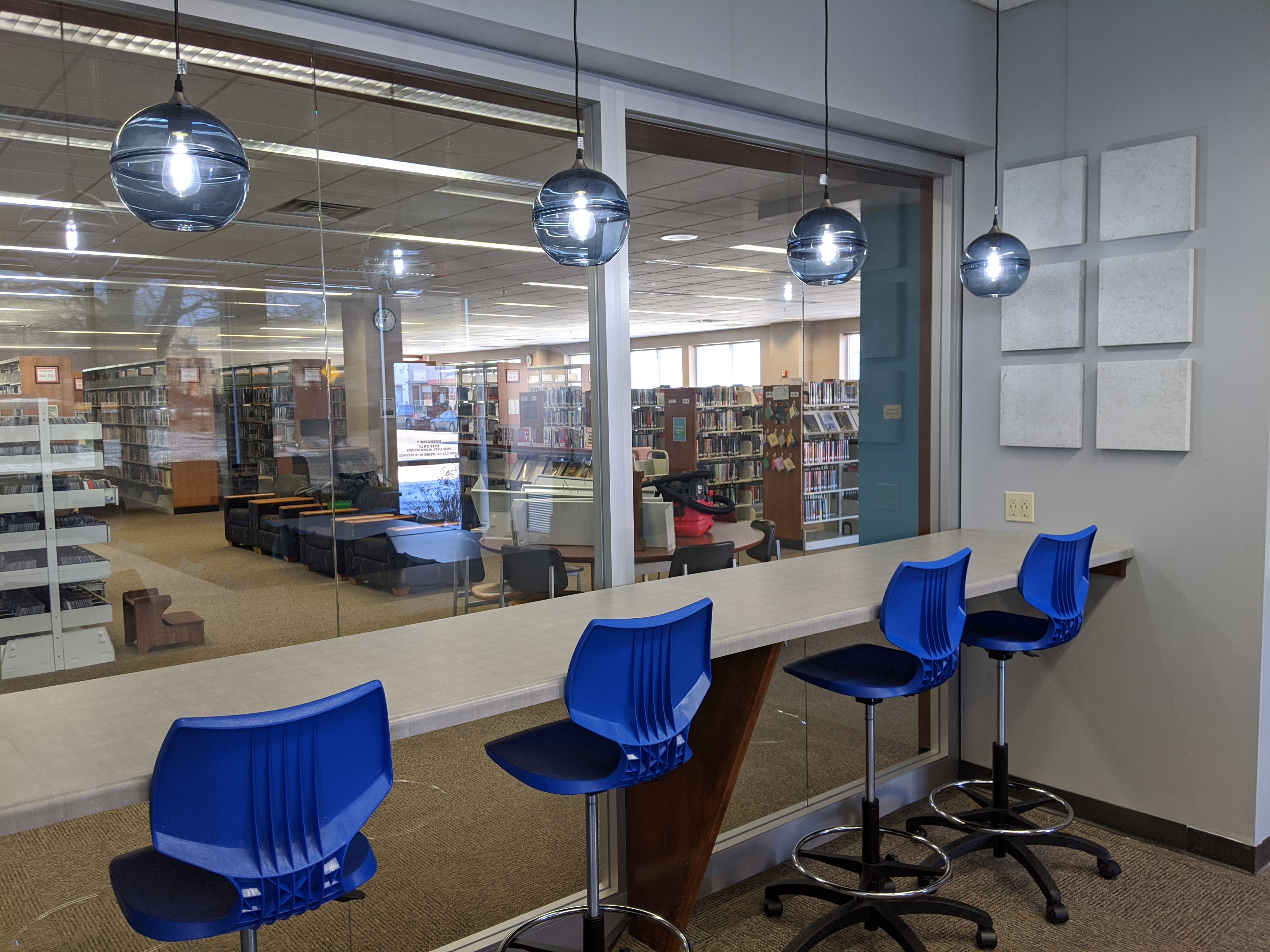 Stools at counter under blue accent lights in Idea Box