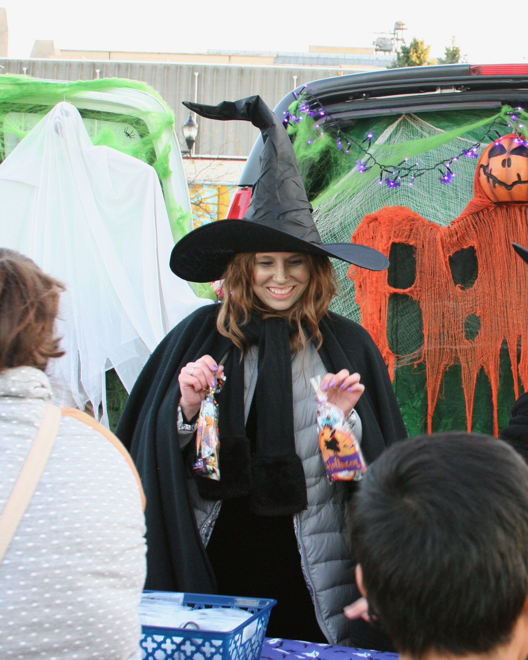 Woman dressed as witch handing out treats
