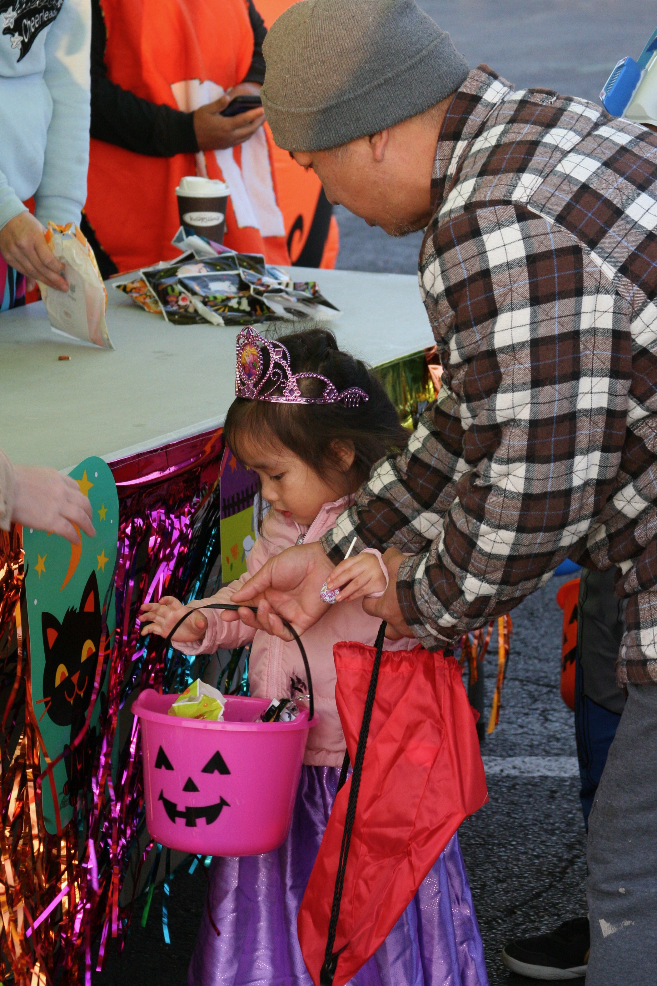 Man with child dressed as princess collecting candy