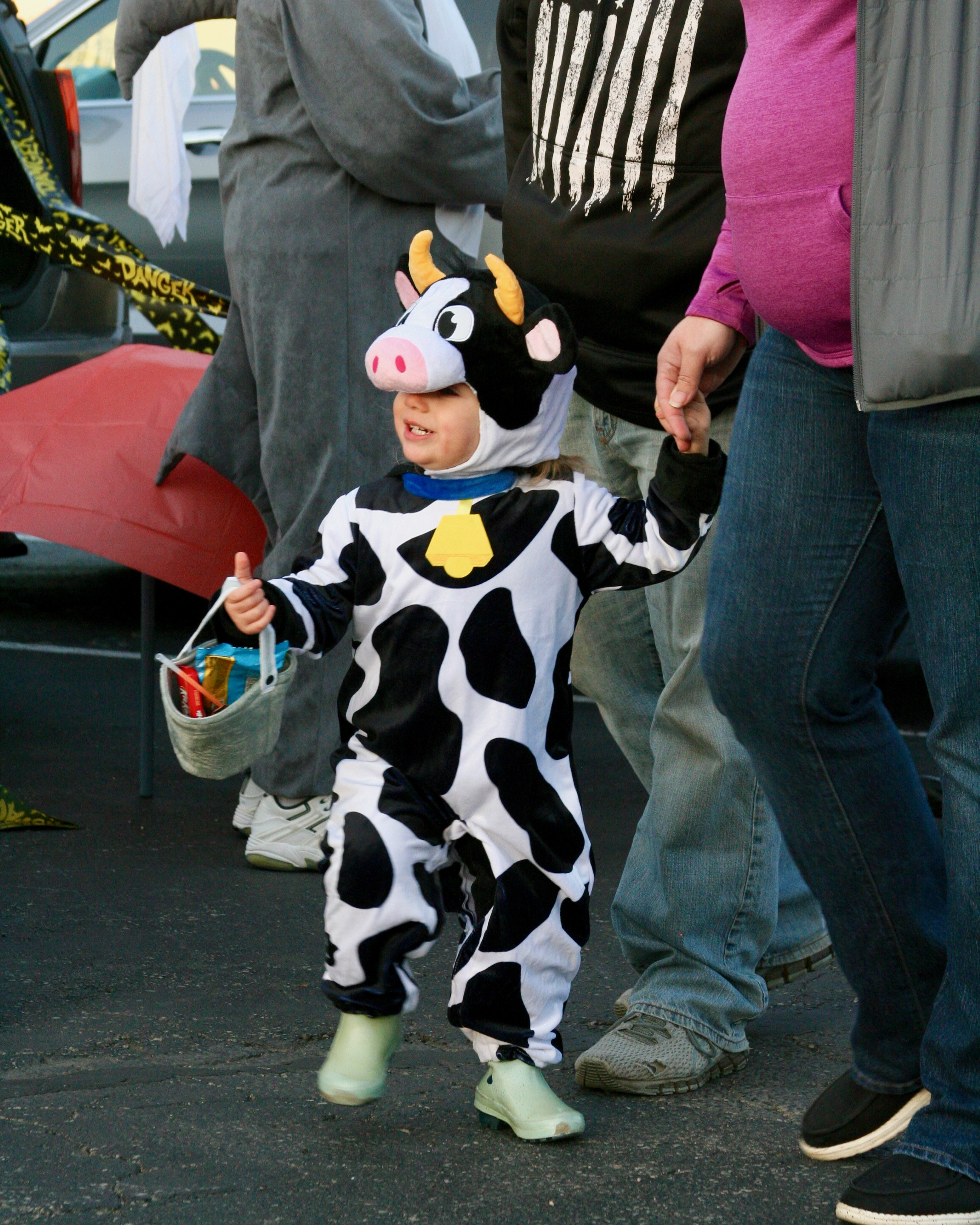 Toddler with candy basket dressed as a cow