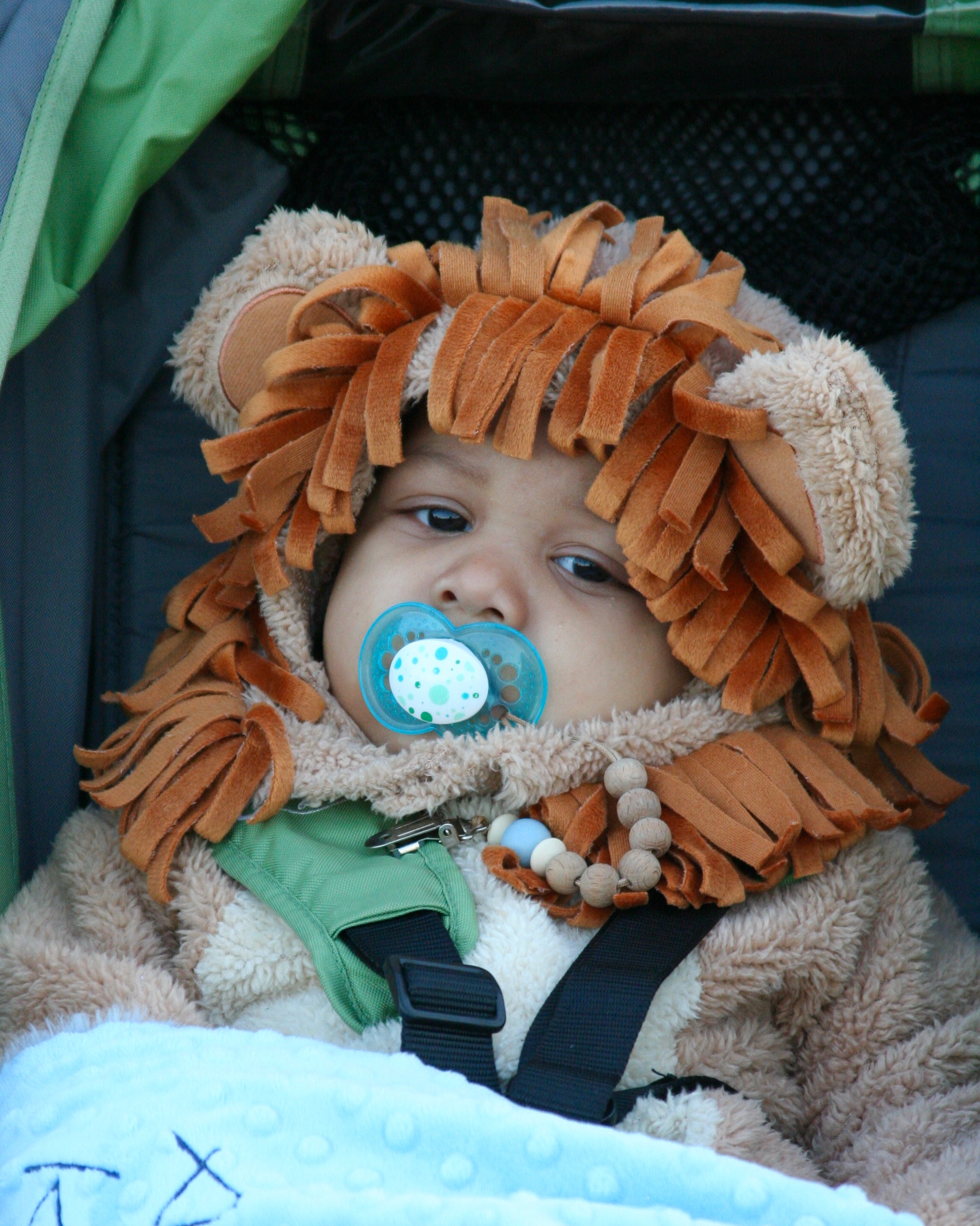 Infant with pacifier dressed as a lion