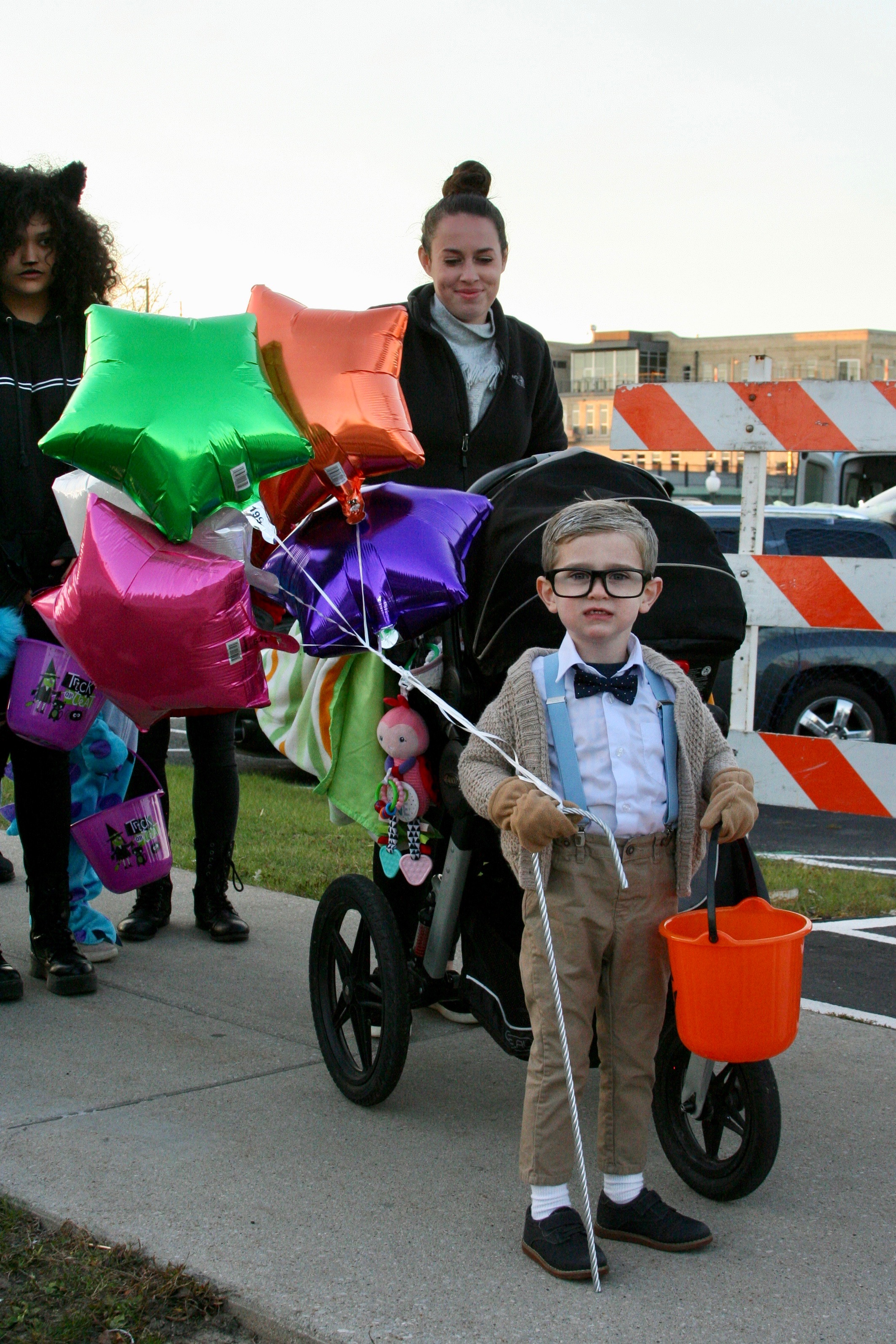 Costumed child holding balloons