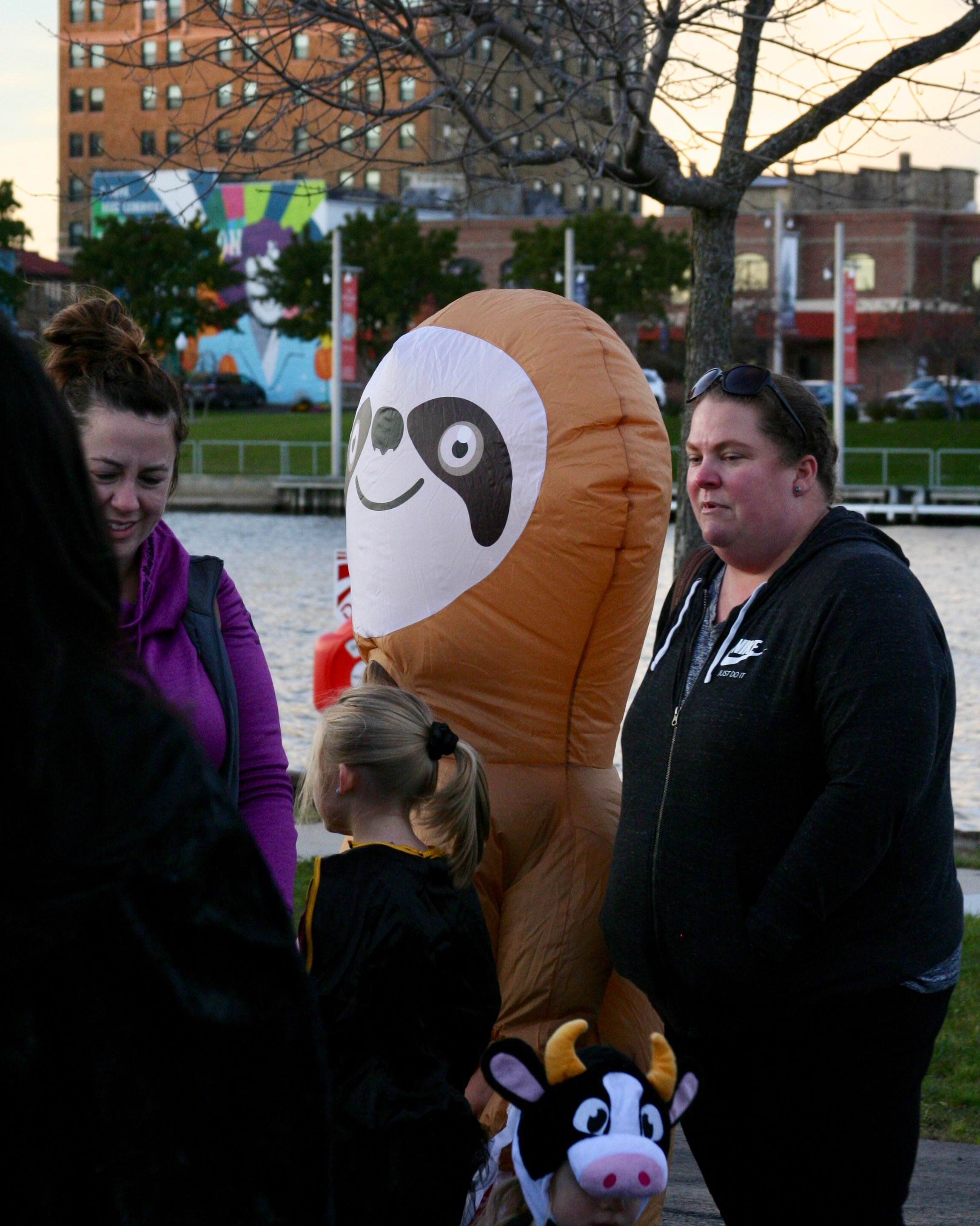 Participants at event, including person in inflatable sloth costume
