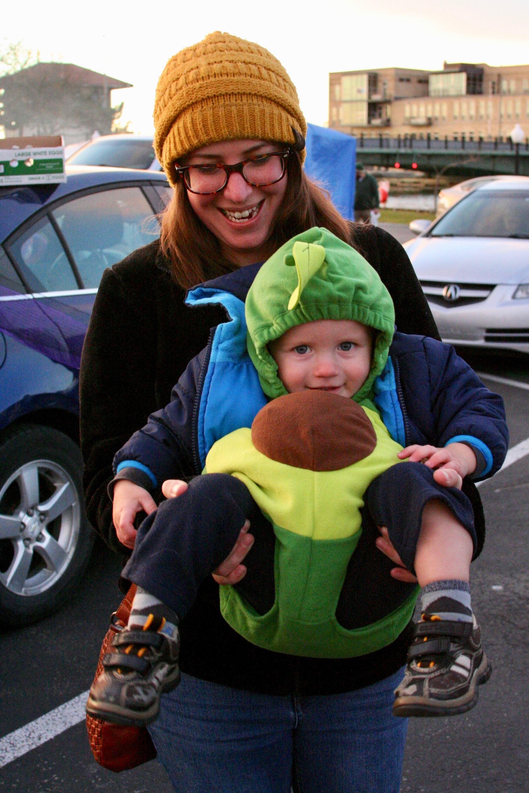 Woman holding child dressed as an avocado