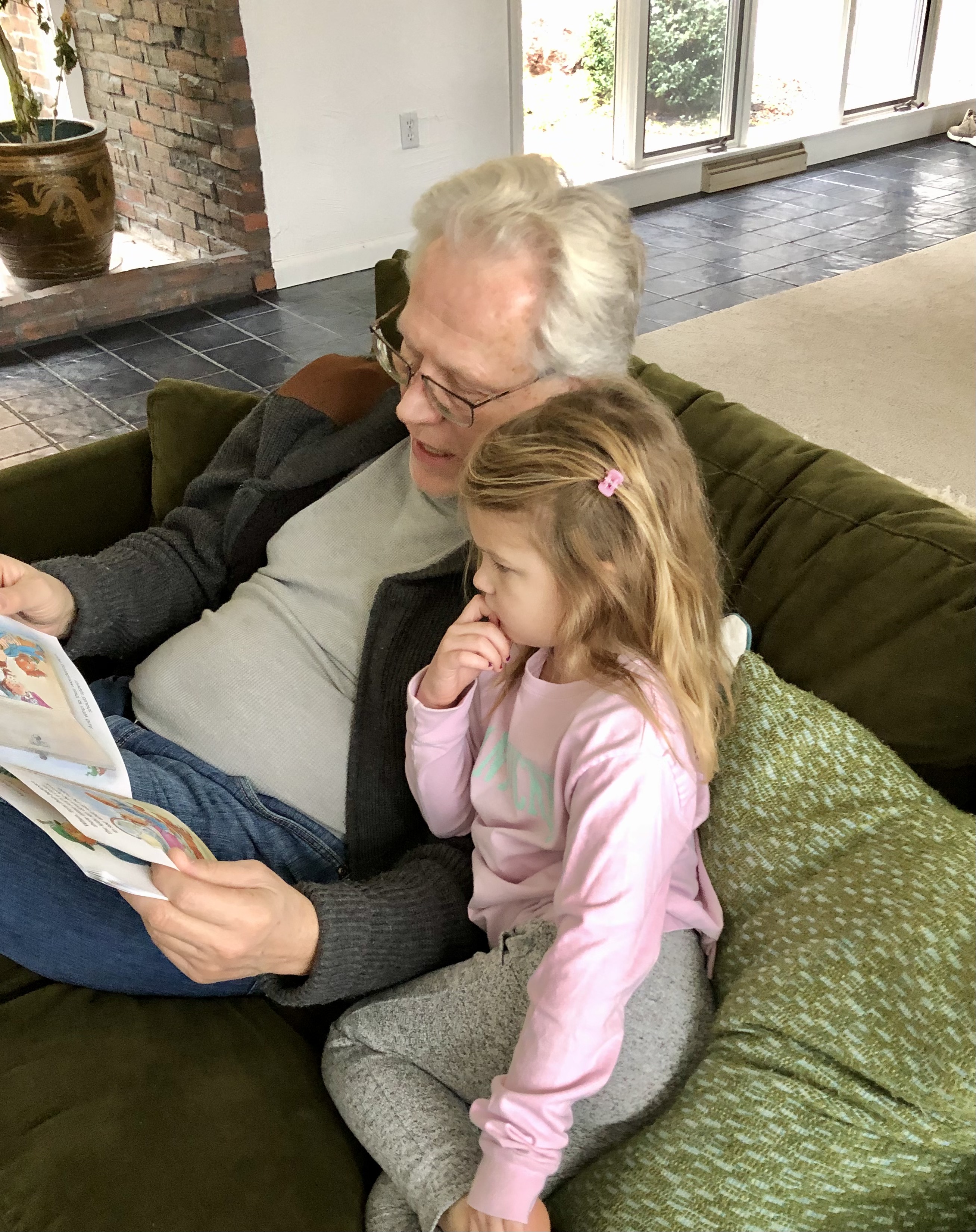 Older man reading to young child