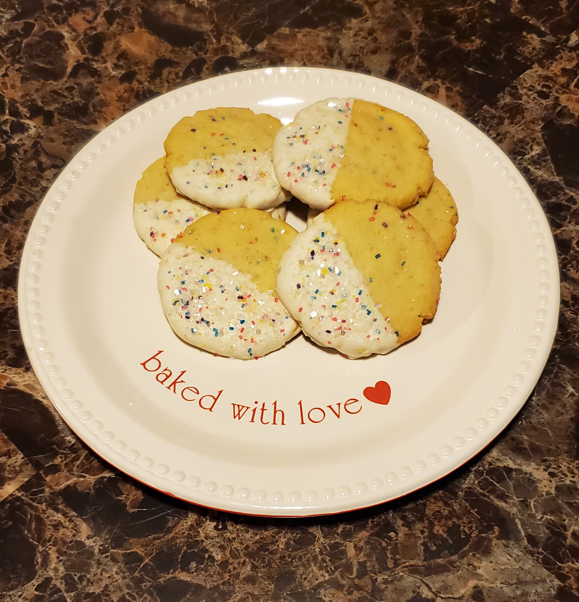 Cookies half-dipped in white chocolate and sprinkles