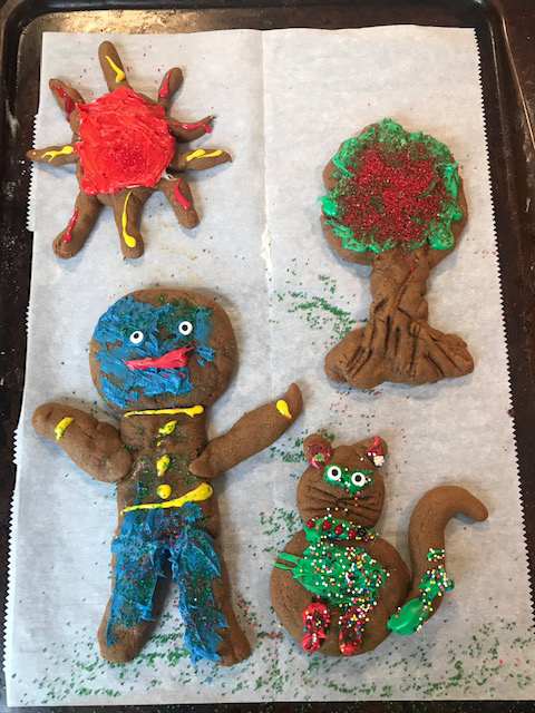 Decorated cookie scene featuring child, sun, cat, and tree