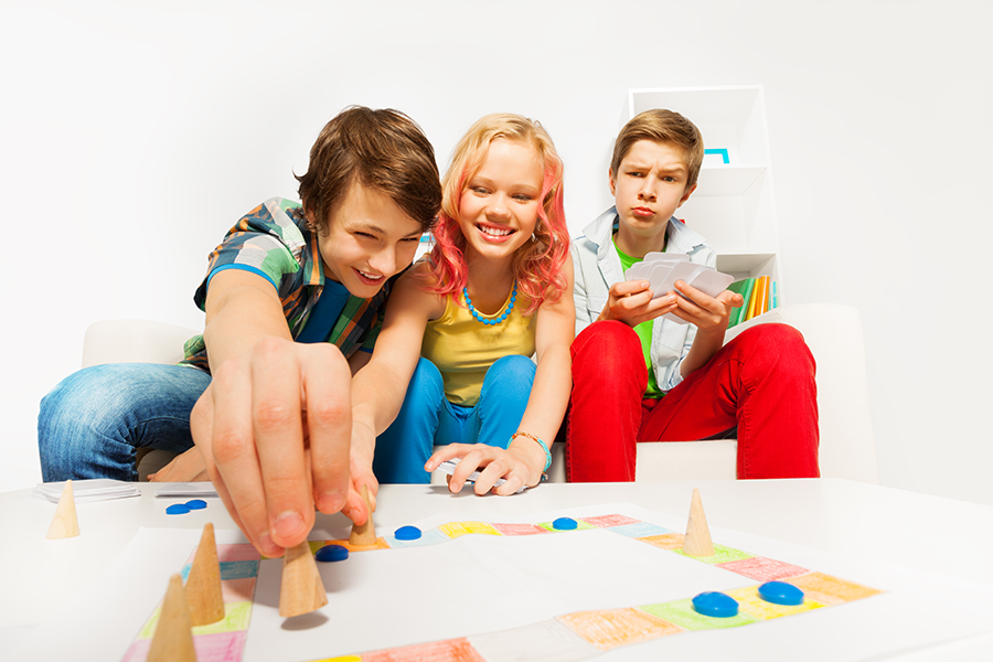 A group of three teens playing board games