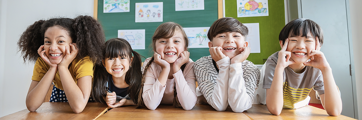 Five students smiling in the classroom