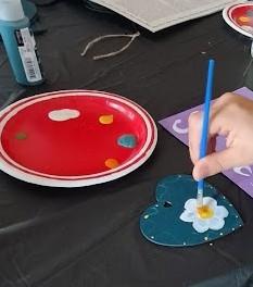 Photo of a flower being painted onto a heart shape