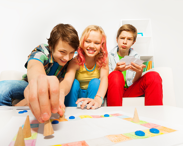 A group of three teens playing a board game